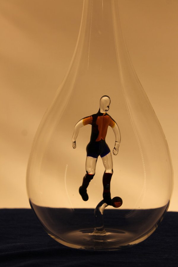 Mundgeblasene Flasche mit einem Fußballer innen